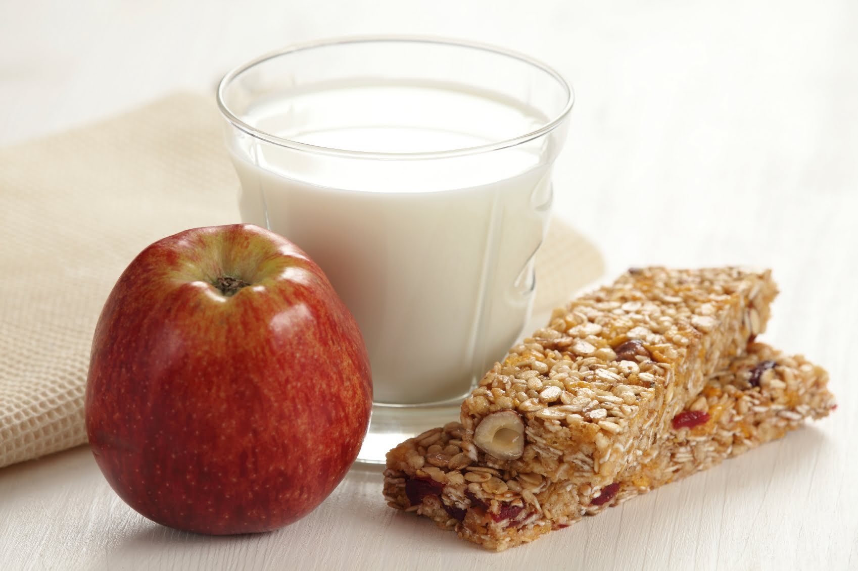 Barre granola avec verre de lait et pomme